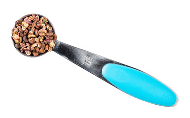 pink sichuan pepper in measuring teaspoon cutout