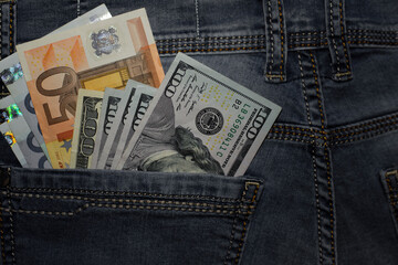 dollar and euro, bills in the pocket of jeans. The concept of pocket money. Cash. American and European money. business, trade or financial transactions, seasonal discounts. close-up