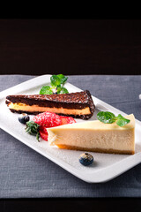 Slice of chocolate vanilla cheesecake on plate against a rustic white wood table