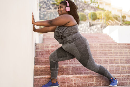Curvy african girl doing sport workout routine outdoor in the city - Focus on face