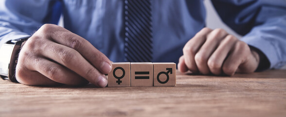 Man showing male and female symbols on wooden cubes. Concept of gender equality
