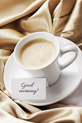 A cup of white coffee or cappuccino and good morning card