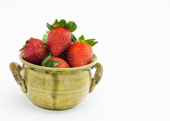 Dojrzałe, czerwone truskawki, w zielonej, ceramicznej miseczce, na białym tle
