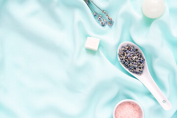 Lavender flowers, coconut soap and pink salt on a blue silk cloth, eco beauty concept