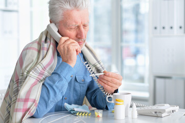 Portrait of sad sick senior man with headache