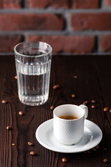 A cup of espresso macchiato with glass of water