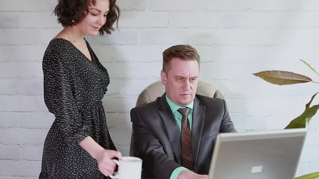 Young assistant gently touches her confused boss, he removes his hand, flirting, harassment at work in the office. Selective focus