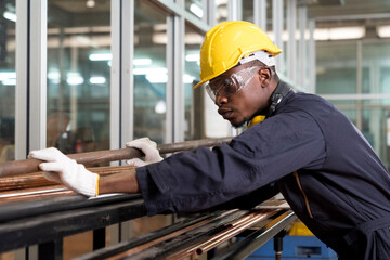 A worker at the factory. New steel pipes. Engineer is holding in hands a pipe tool. Tube tool.