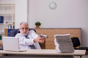 Old male employee being desperate with excessive work in the off