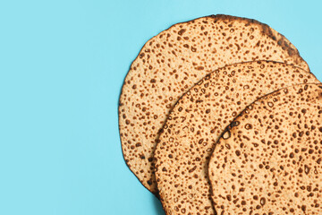 Tasty matzos on light blue background, flat lay with space for text. Passover (Pesach) celebration