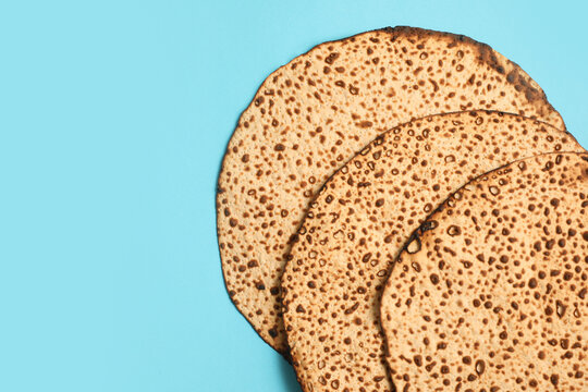 Tasty matzos on light blue background, flat lay with space for text. Passover (Pesach) celebration