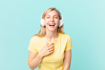young blonde woman laughing out loud at some hilarious joke and listening music.