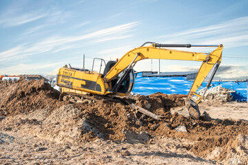 excavator bulldozer digging dirt ground, shoveling ion the construction site