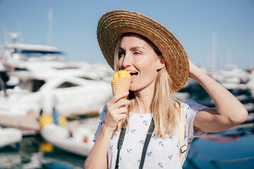 Young happy cheerful caucasian woman eating sorbet ice cream on a summer day.