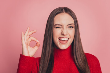 Young woman showing ok sign with fingers winking eye