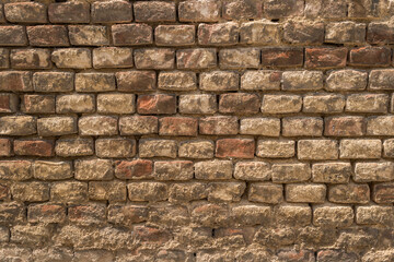 Old brick wall with fallen plaster