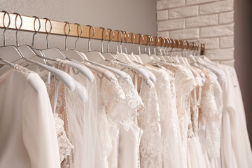 Different wedding dresses on hangers in boutique