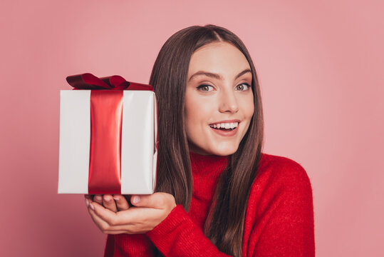 Portrait of lovely girl getting receiving giftbox isolated over pink background