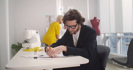 Obraz premium Three professional fashion designers working in modern atelier