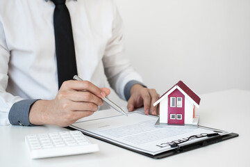 Businessman working real estate and investment, checking a contract document of home loan insurance in the office.