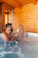 Couple relaxing and making a toast in a hot tub