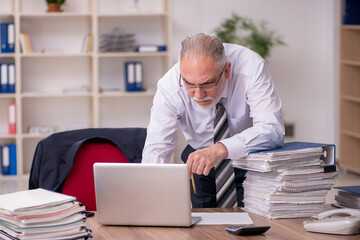 Obraz premium Aged male employee unhappy with excessive work in the office