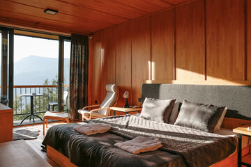 Interior of the room with wooden walls and full lengths window of mountain cabin. Copy space for...