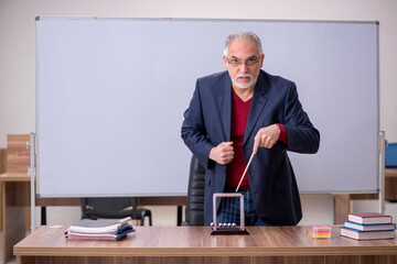 Old teacher physicist sitting in the classroom