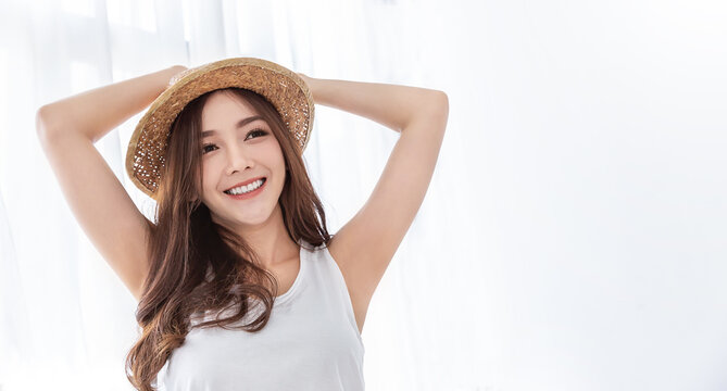 Portrait of young beautiful asian woman on holiday vacation summer time in white bedroom. Happy cheerful girl in summer. Korean makeup under arm skincare. University woman fashion lifestyle banner