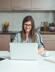 Smiling Business Woman Using Laptop for Teleconferencing .
Happy  businesswoman working at home with laptop computer, having conference call online meeting with colleagues during pandemic.