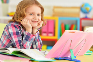 Cute teen girl doing homework in her room