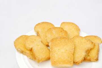 Crispy garlic bread on white plate on blue and yellow background