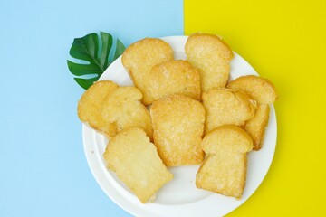 Crispy garlic bread on white plate on blue and yellow background