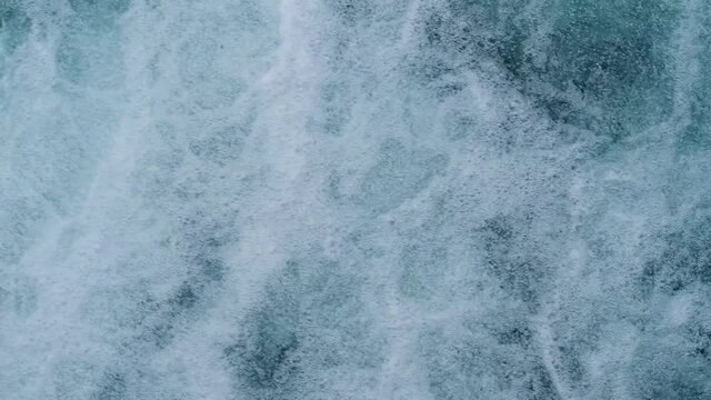 streams of water seethe in powerful waterfall, historic dam on Reuss river flowing from Lake Lucerne in switzerland, top view of stream bubbles, rippled liquid textured surface background