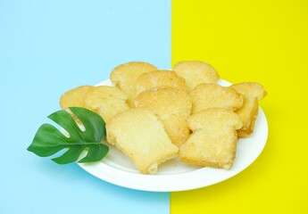 Crispy garlic bread on white plate on blue and yellow background