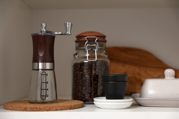 Manual coffee grinder on shelf in kitchen