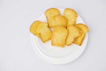 Crispy garlic bread on white plate on blue and yellow background