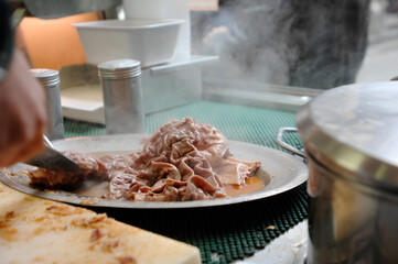 Lampredotto is the typical street food of the city of Florence in Tuscany and is a sandwich with a cow's stomach in a tomato sauce and put to stew