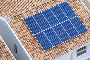 Painéis solares no telhado de uma casa. Economia de energia, meio ambiente e energia renovável. - obrazy, fototapety, plakaty