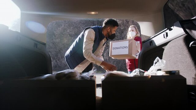 Volunteers in community donation center delivering meals. Food bank and coronavirus concept.