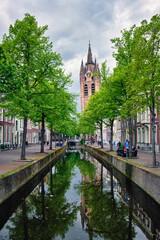 Naklejka premium Delt canal with bicycles and cars parked along. Delft, Netherlands