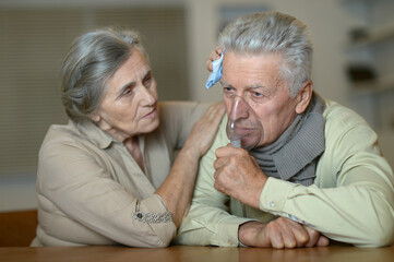 Portrait of sick senior man  holding inhaler