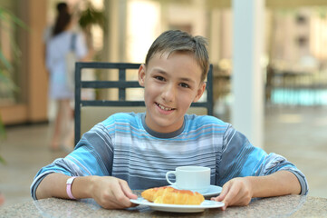 boy  drinking tea with croissants