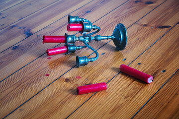  tin candleholder with red candles fallen on wooden floor