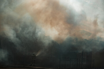 the fire destroys the building. the fire brigade pours water on the burning house. people are suffocating from the smoke and smog from the fire. fire victims