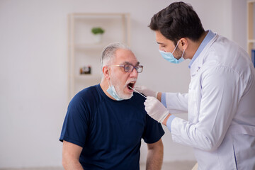Fototapeta premium Old male patient visiting young male doctor otorhinolaryngologis