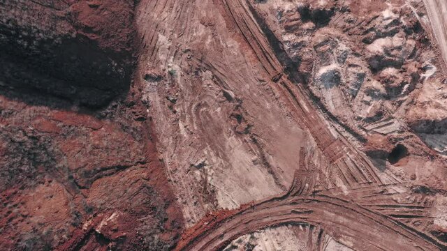 The surface of a clay quarry for the extraction of red clay. The surface of the quarry near the mines of red clay with the lake - aerial shot.