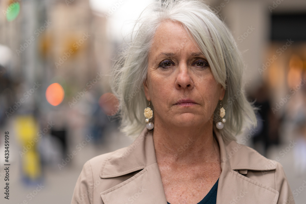 Poster Mature caucasian woman in city serious sad face portrait