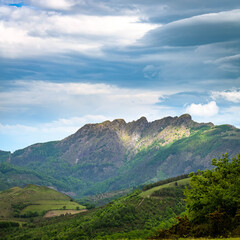 Naklejka premium Green vivid mountains covered with threatening stormy clouds