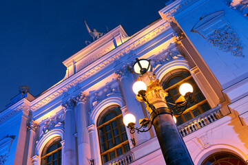 Detailds of the main building of Warsaw University of Technology at dusk lit by colorful lights....
